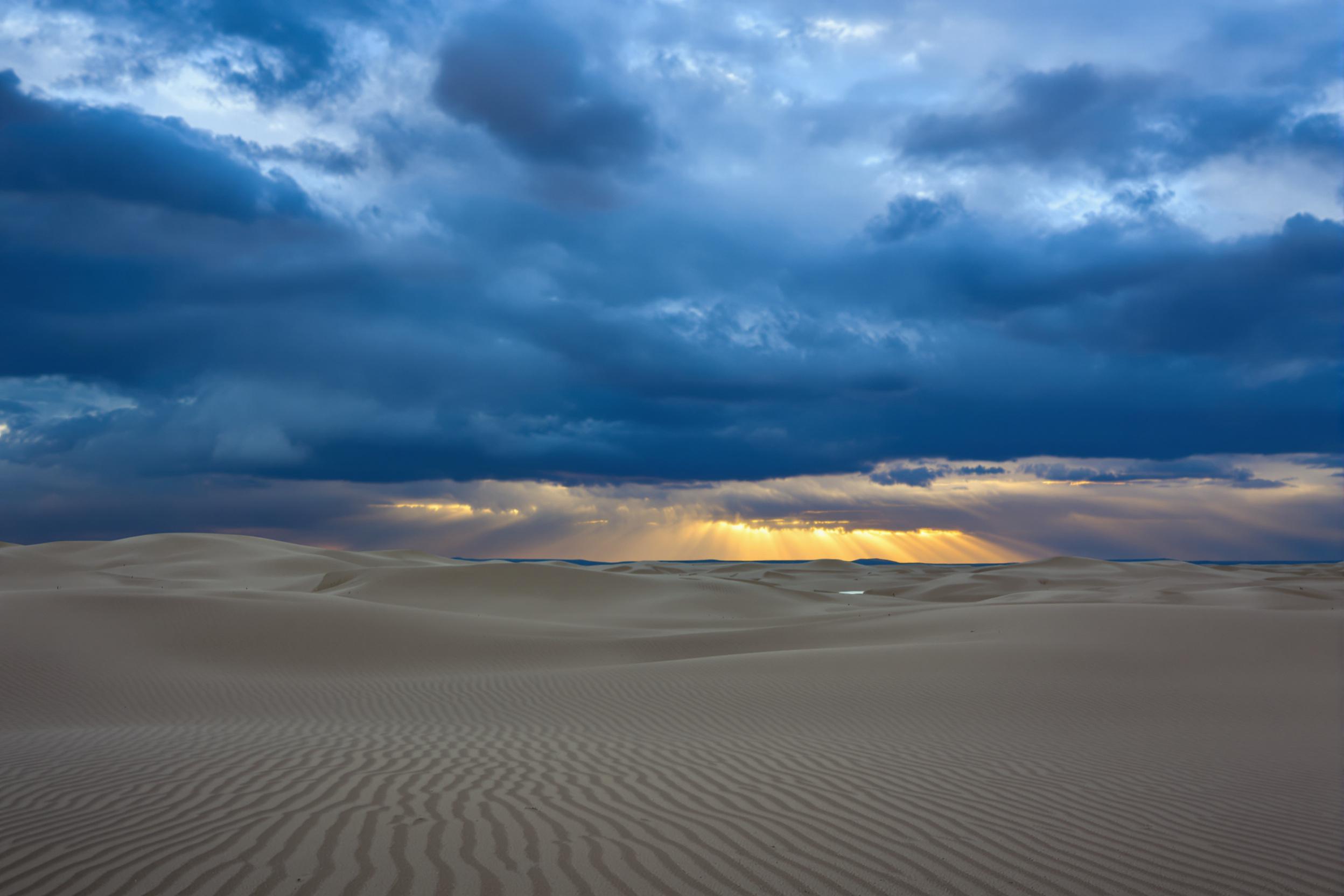 Storm Clouds Over Windswept Desert Dunes