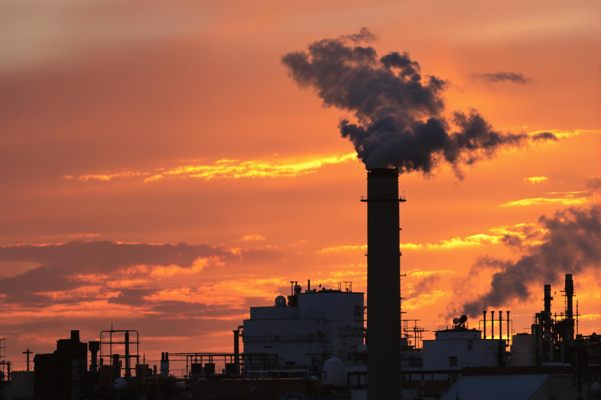 Industrial Smokestack at Sunset with Billowing Smoke