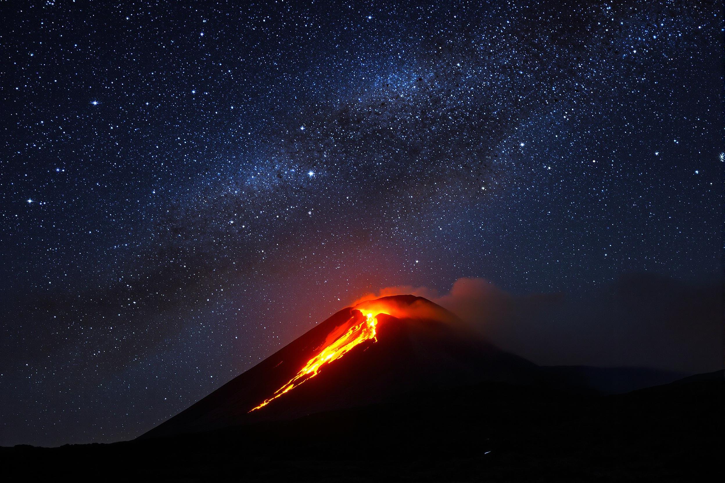 Majestic Volcanic Eruption Under Starry Night Sky