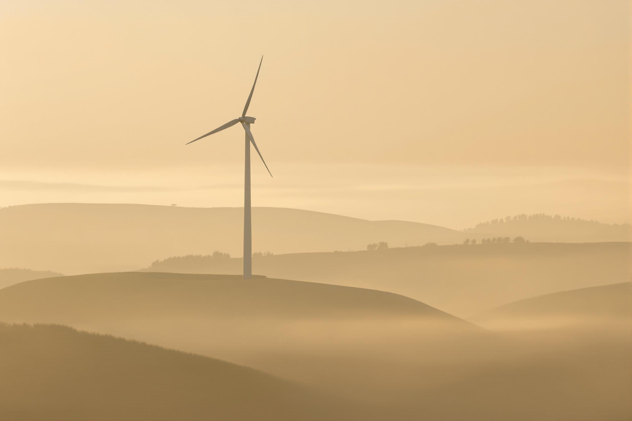 Lone Wind Turbine in Foggy Dawn Vista