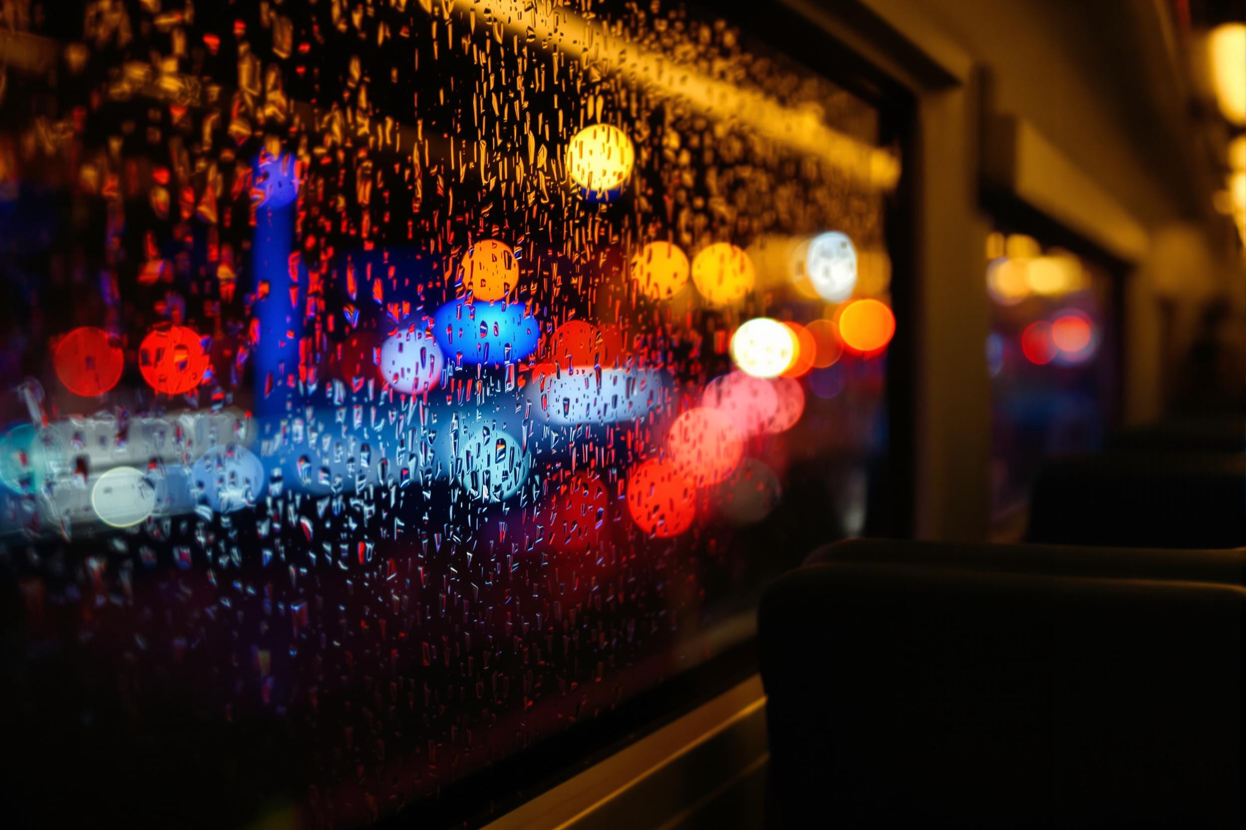 Rainy Night Train View with City Light Reflections