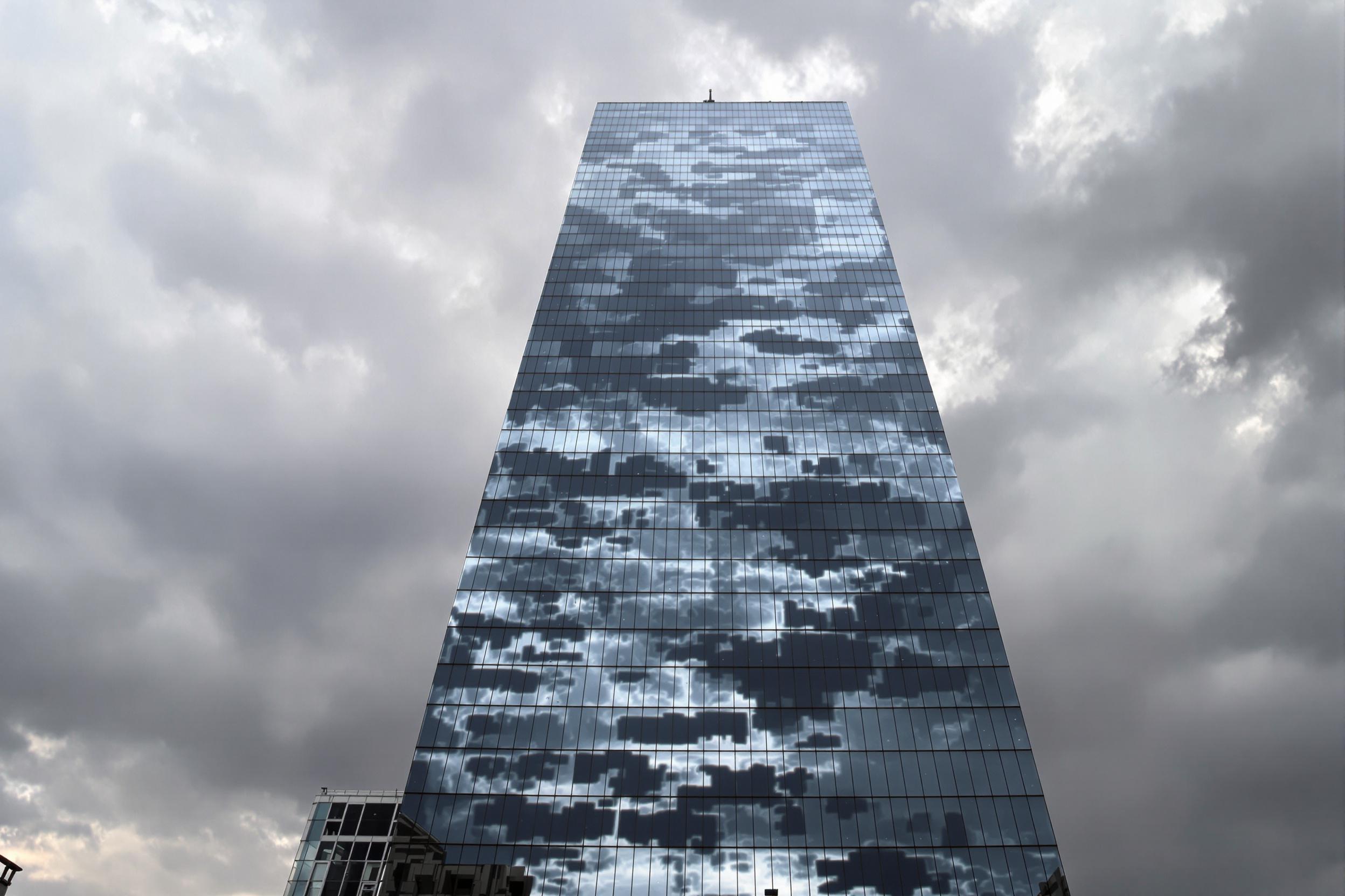 Reflective Skyscraper Against Looming Storm Clouds